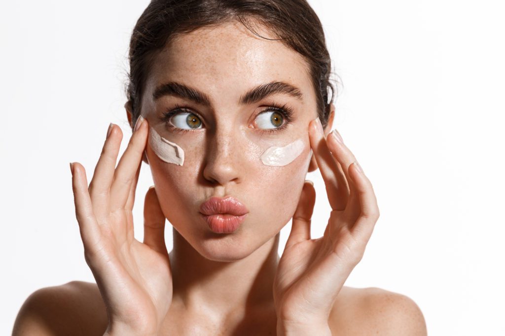 photo of woman applying skincare product
